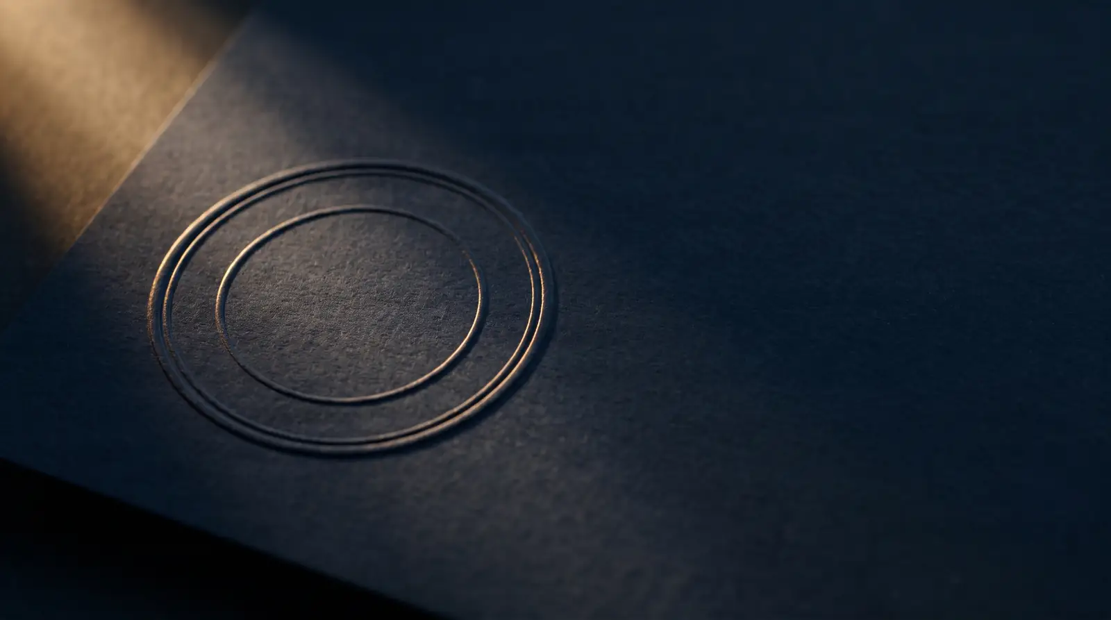 A brass seal and a folded document on deep navy fabric